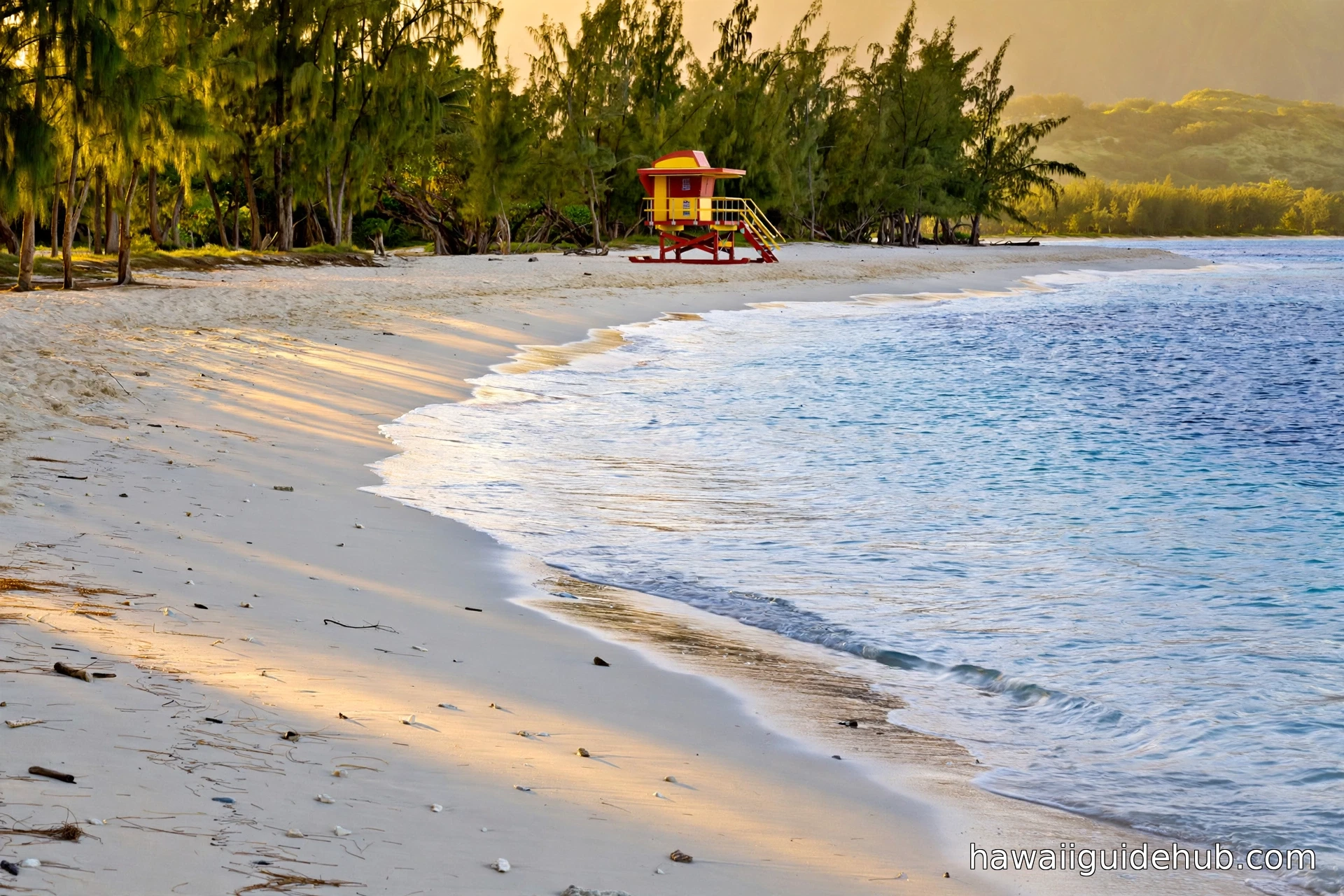 Bellows Beach shoreline at golden hour with a lifeguard tower, white sand and turquoise water