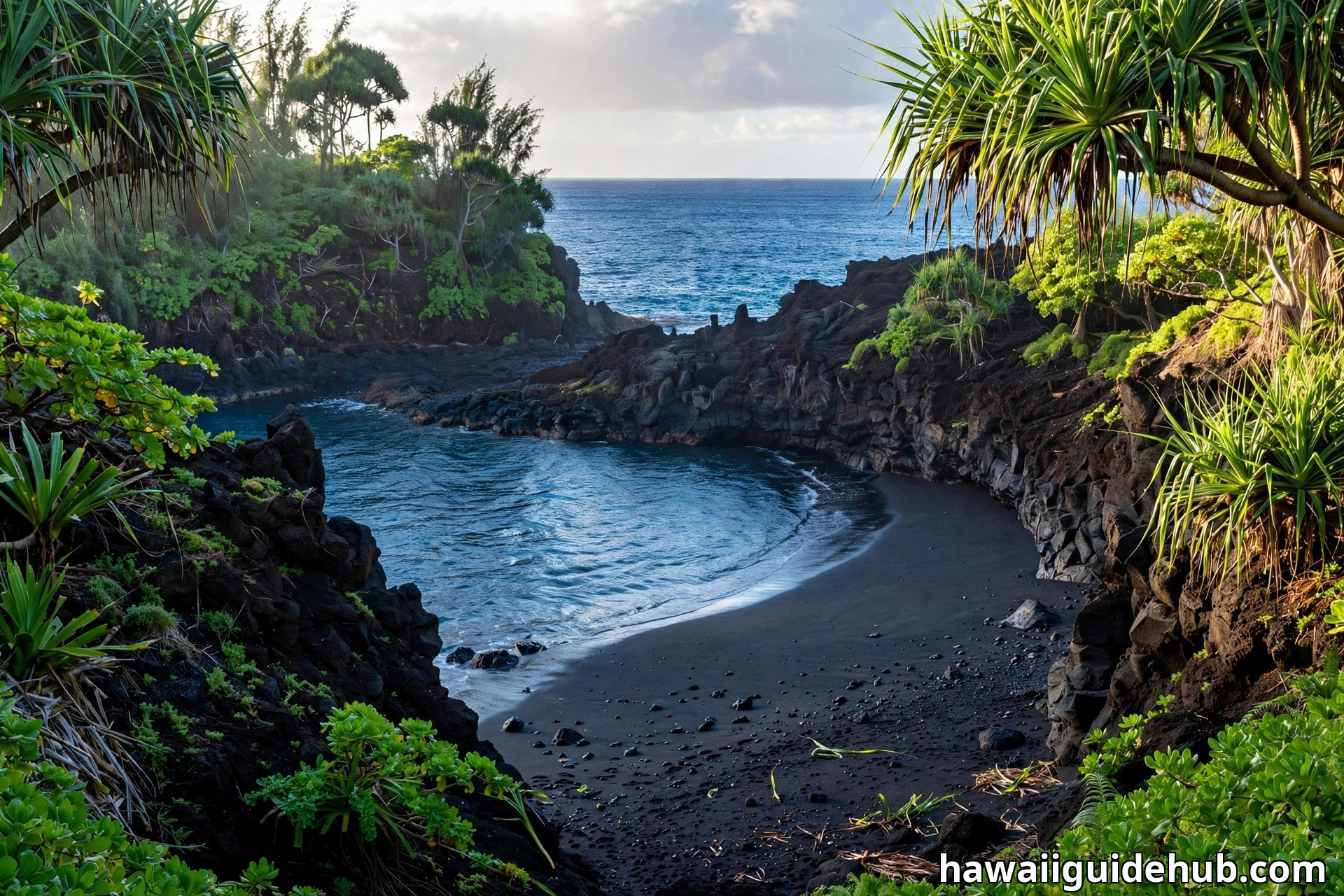 Wai'anapanapa State Park's black sand cove on Maui, dark sand inside curved lava rock cliffs with turquoise water