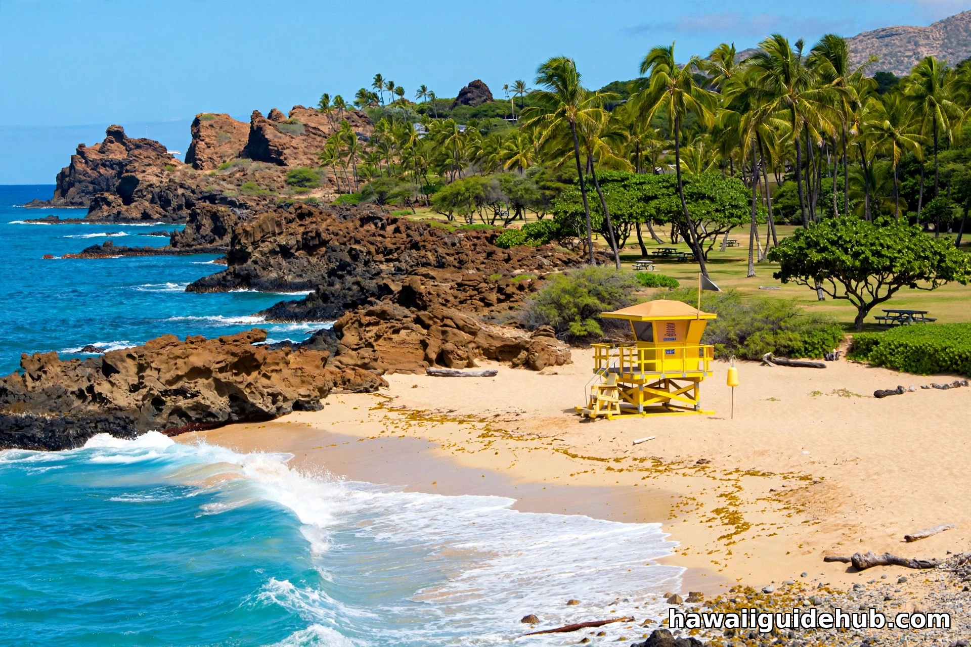 Kahe Point Beach Park shoreline with lifeguard tower, sandy beach, and rocky coastline on Oahu