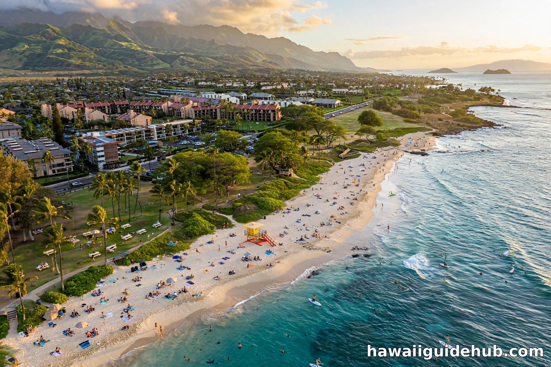 Aerial view of Kamaole Beach Park in Kihei, Maui, with white sand beach, turquoise ocean, lifeguard tower, and the islands of Molokini, Kahoolawe, and Lanai on the horizon