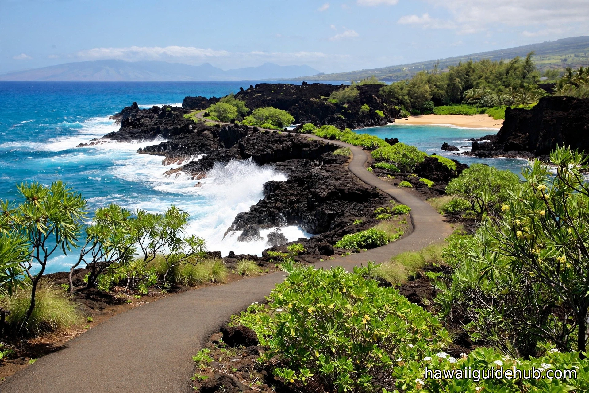Paved Kapalua Coastal Trail winding past black lava rock formations with turquoise ocean waves and a small sandy cove on Maui