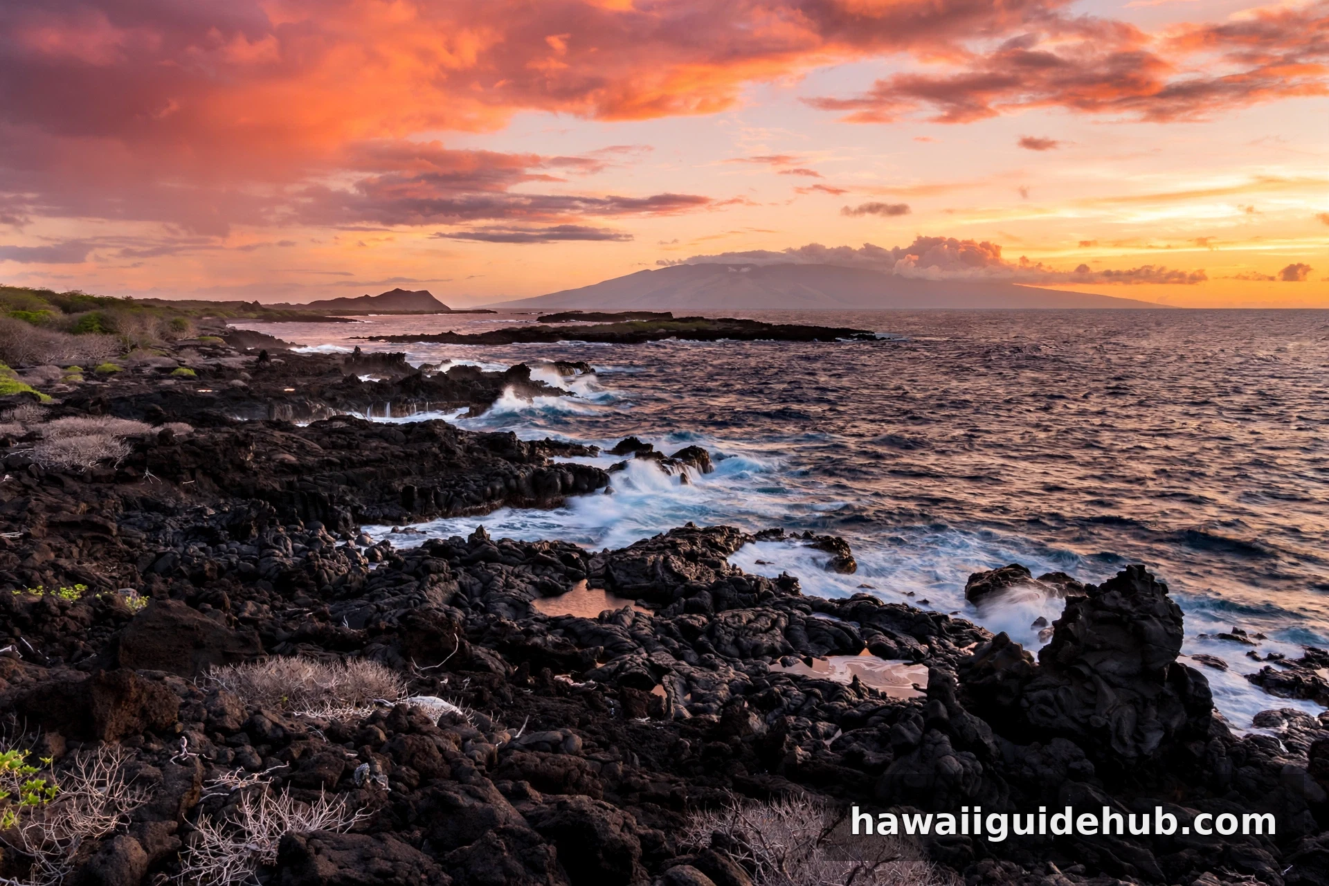 Sunset over the lava rock Kohala coast with the island of Maui on the horizon, Big Island of Hawaii