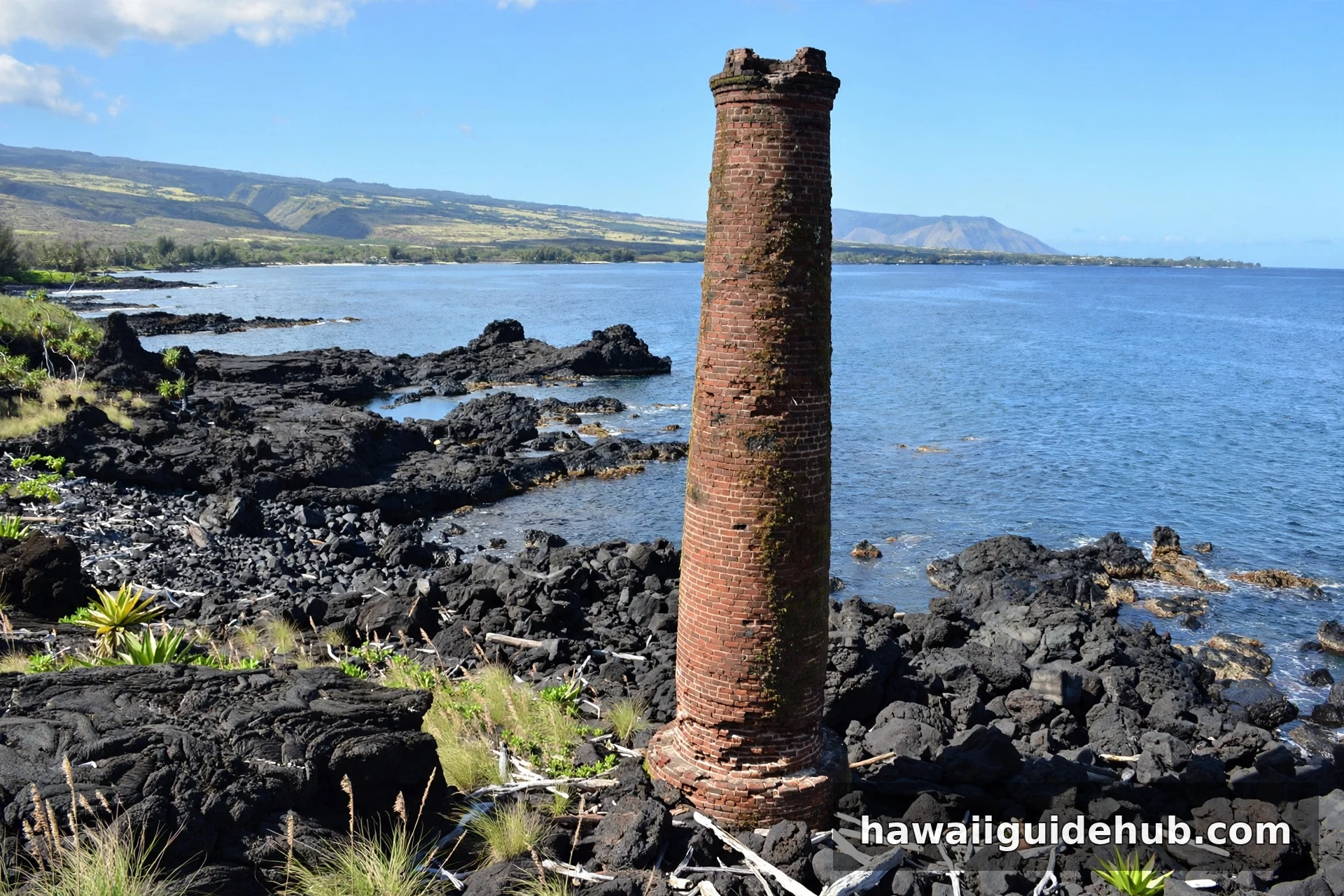 Old sugar mill smokestack on the lava rock shoreline at Mahukona Beach Park, Big Island of Hawaii