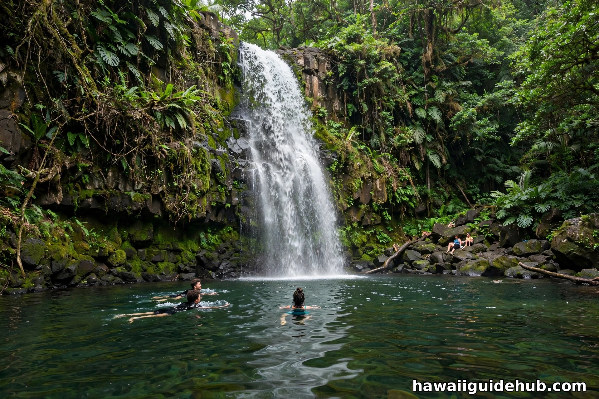 Swimmers enjoying the deep natural pool below Maunawili Falls waterfall on Oahu
