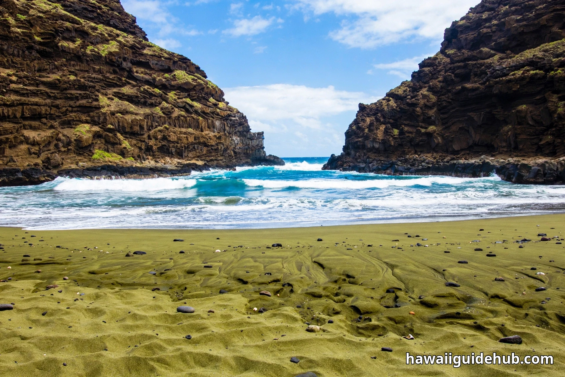 Green olivine sand shoreline inside Papakolea cove with turquoise waves and steep volcanic crater walls on Hawaii Big Island