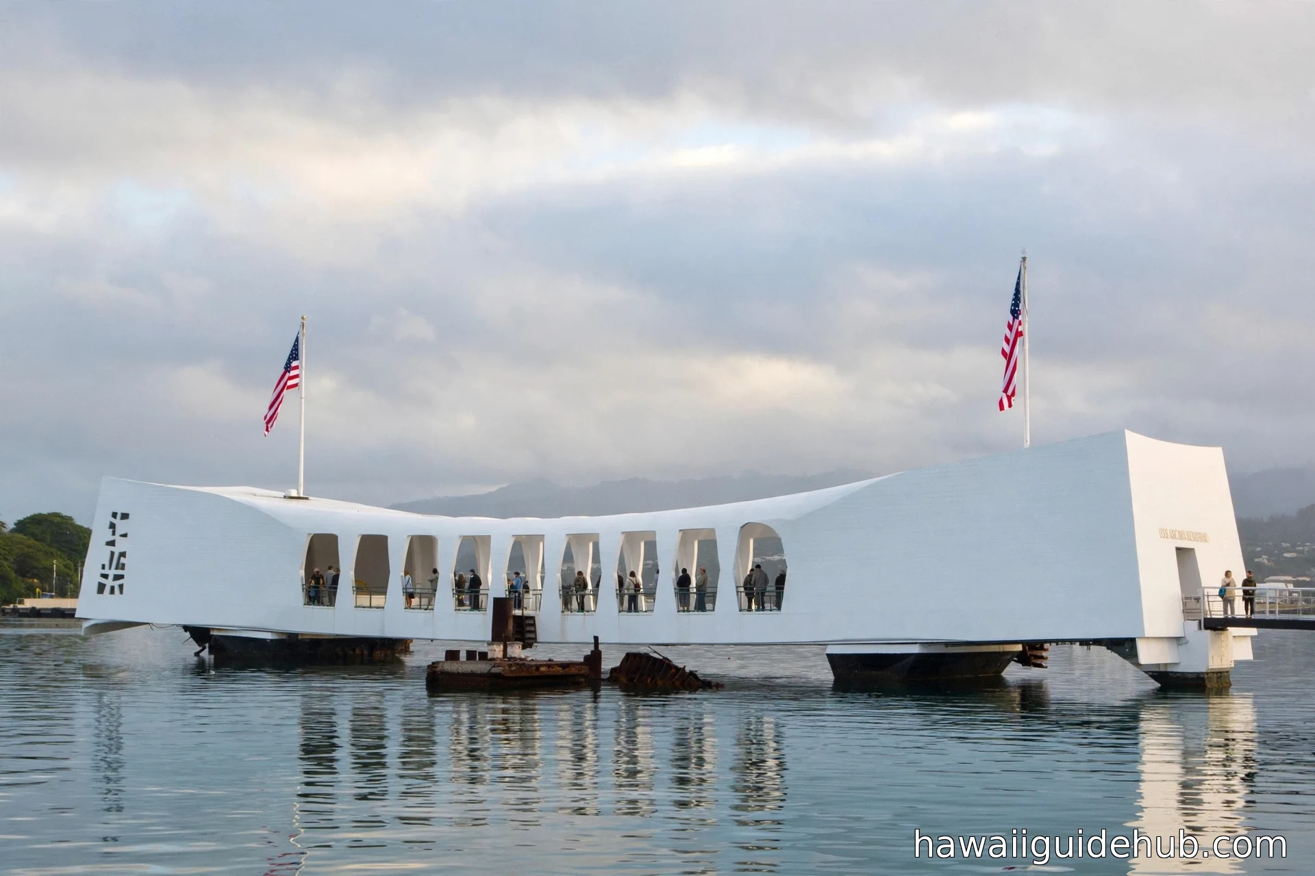 The white USS Arizona Memorial stretching across the calm water of Pearl Harbor, Oahu
