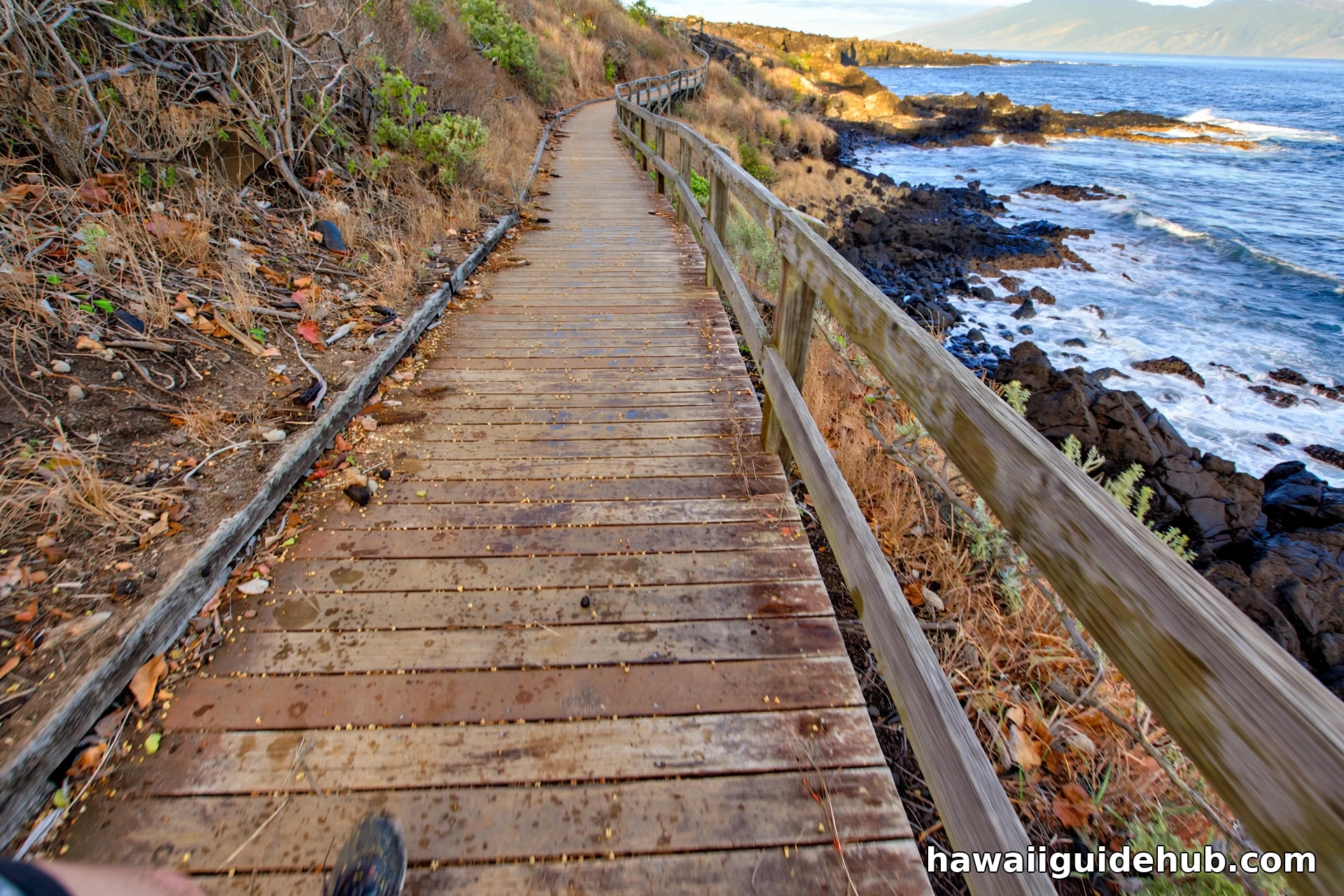 Wooden boardwalk section of the Kapalua Coastal Trail along the rocky Maui shoreline