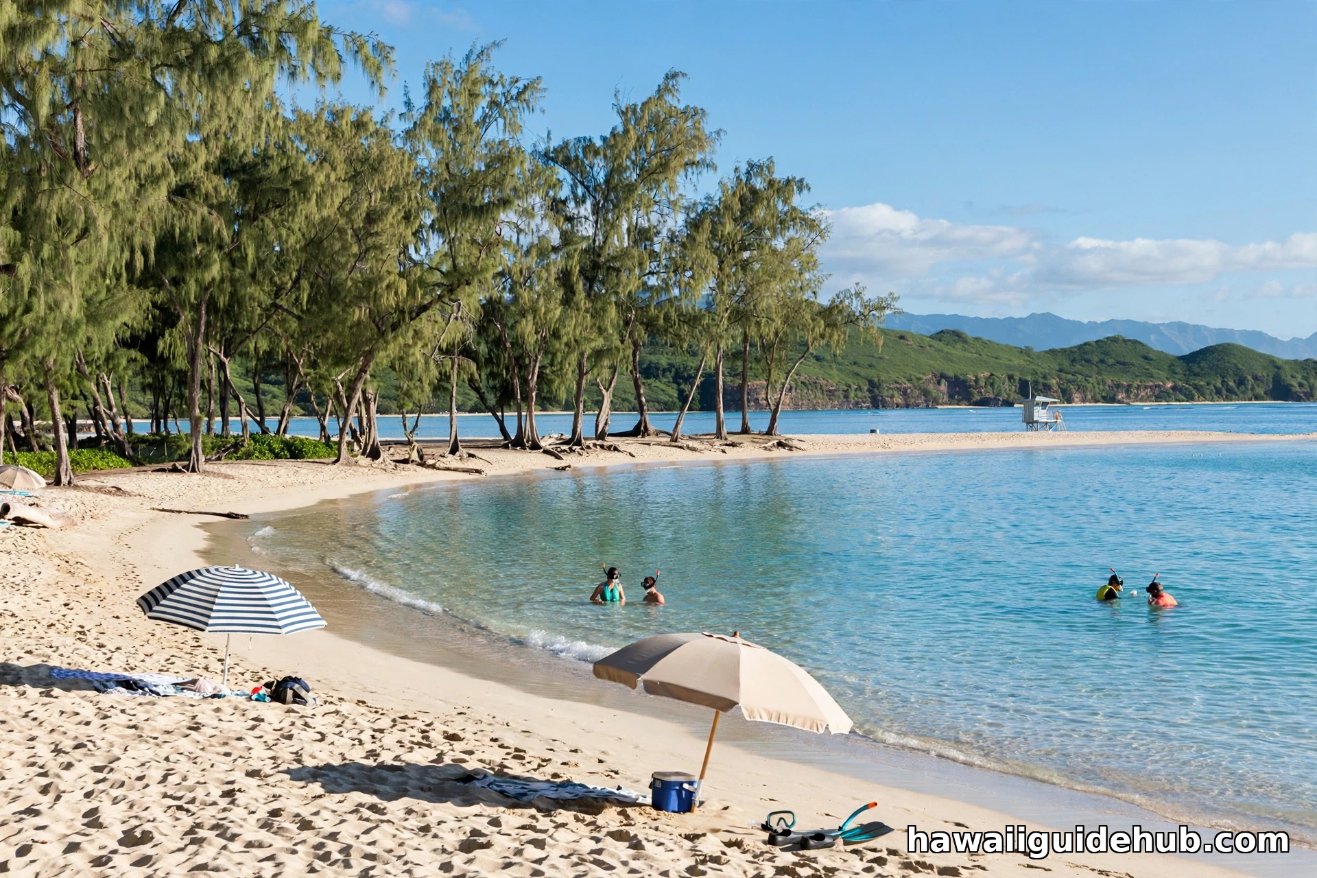 Calm summer morning at Sunset Beach Oahu with snorkelers in clear turquoise water and beach umbrellas